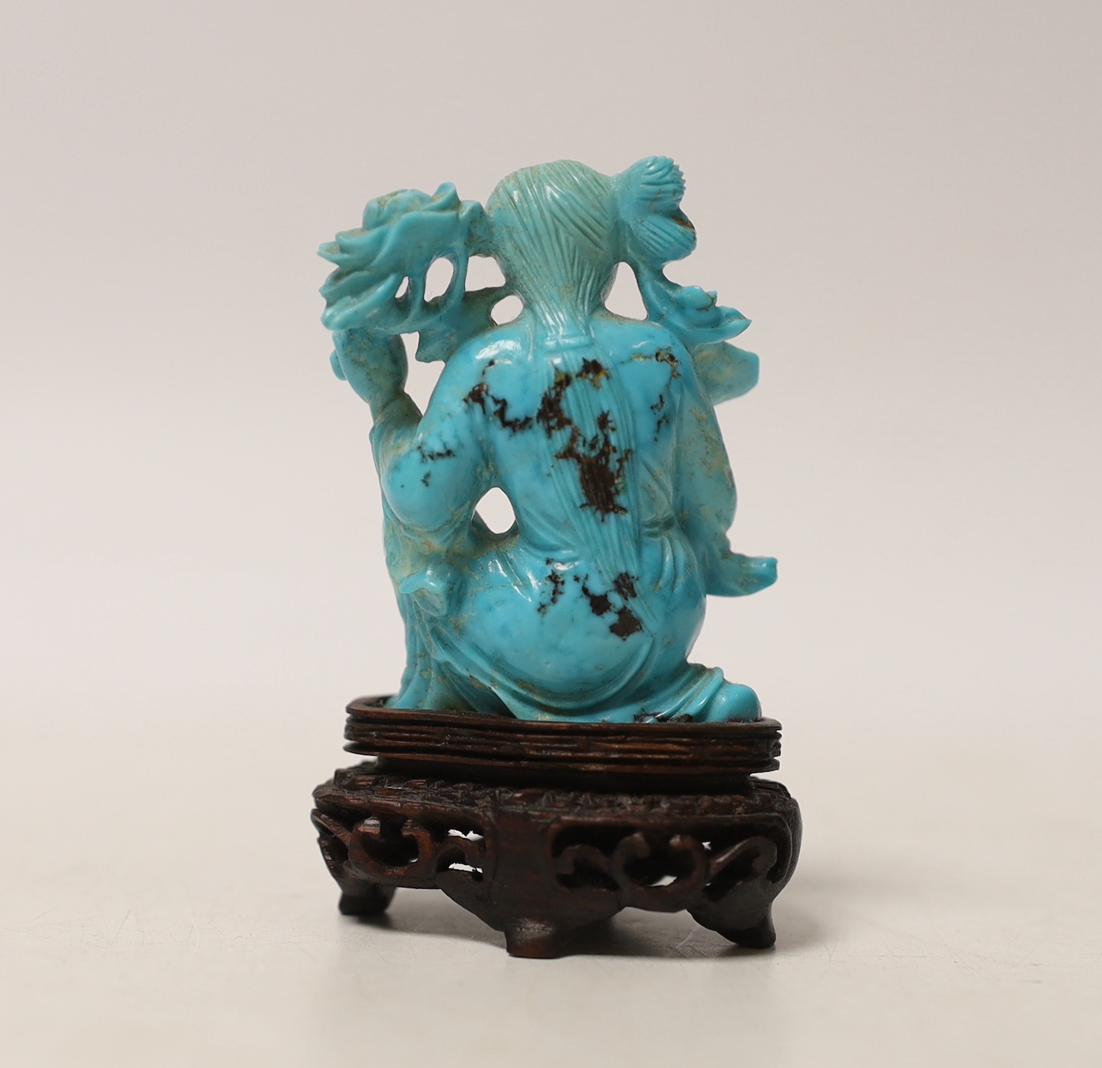 An early 20th century Chinese carved turquoise figure of a lady, on wooden base, 6.5cm high